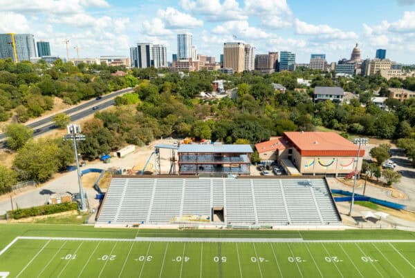 Stadium during construction with city skyline in the background, showcasing Flynn Construction's project expertise.